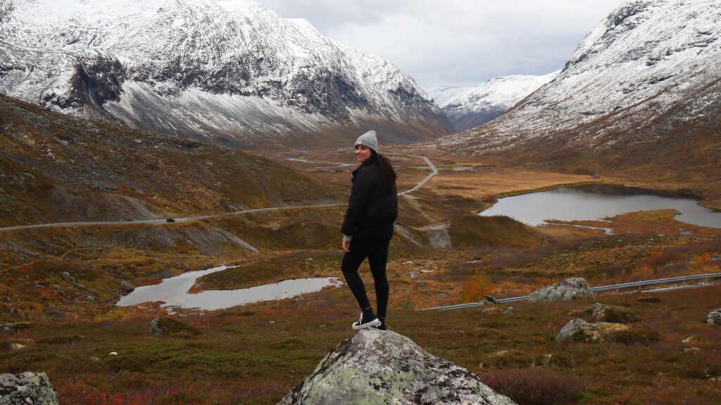 girl stands on rock in front of norwegian valley